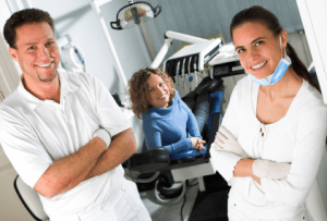 A dental office scene featuring three individuals. 